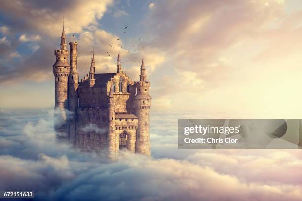 birds flying around castle above clouds - chateau stock pictures, royalty-free photos & images
