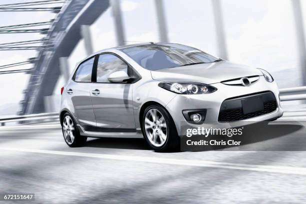 silver car speeding on bridge - autokompaktklasse stock-fotos und bilder