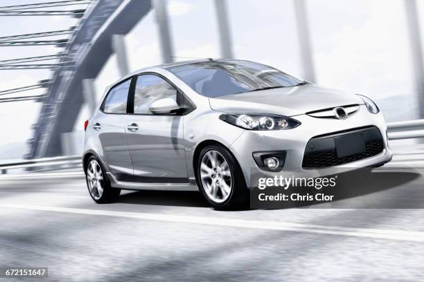 silver car speeding on bridge - car photos stock-fotos und bilder