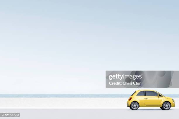 yellow car near ocean - vista de costado fotografías e imágenes de stock