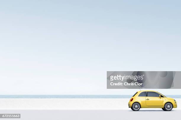 yellow car near ocean - vista laterale foto e immagini stock