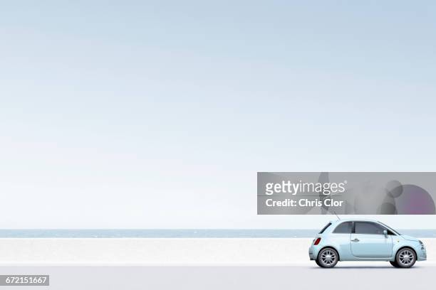 blue car near ocean - compact foto e immagini stock