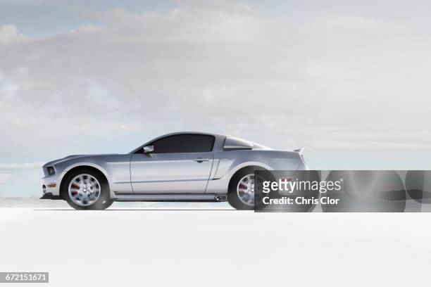 silver sports car in white landscape - seitenansicht stock-fotos und bilder