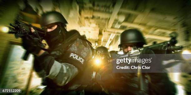 police on the move aiming rifles - task force foto e immagini stock