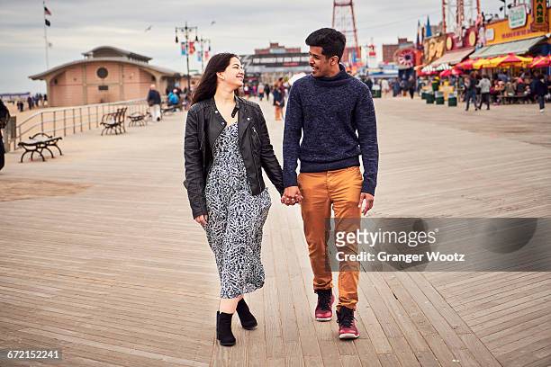 couple walking on boardwalk at amusement park - boardwalk ストックフォトと画像