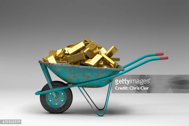 rusty wheelbarrow full of gold bars - gold bars stock-fotos und bilder