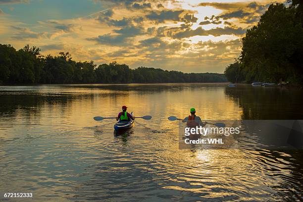 couple kayaking in river at sunset - richmond stock pictures, royalty-free photos & images