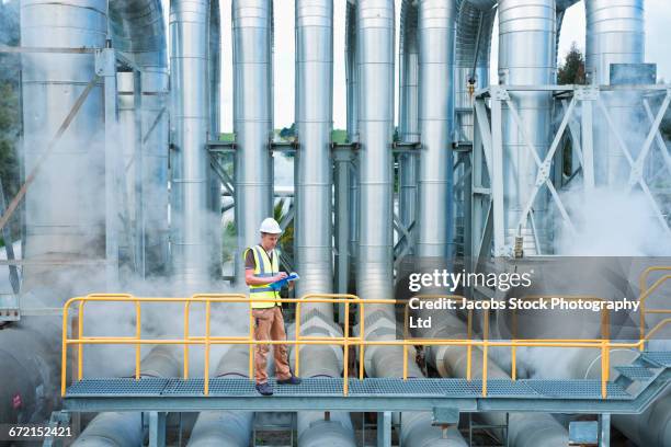 caucasian worker at geothermal power station - railing stockfoto's en -beelden