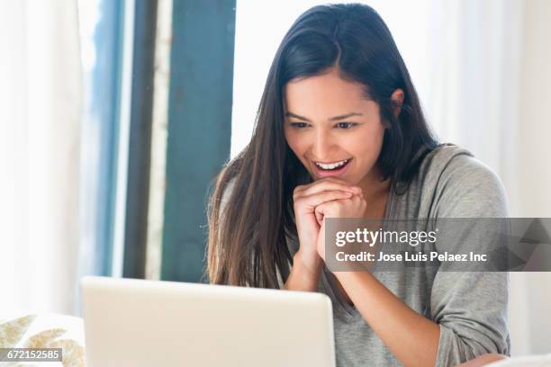 surprised hispanic woman using laptop - excitement laptop stock pictures, royalty-free photos & images