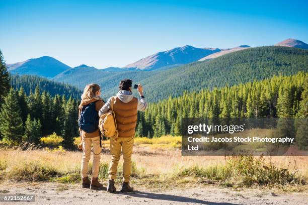 hispanic couple photographing mountains, breckenridge, colorado, united states,  - colorado stock pictures, royalty-free photos & images