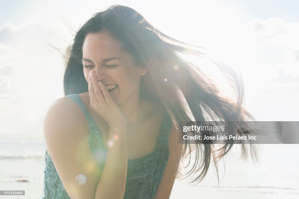 Wind blowing hair of laughing Hispanic woman