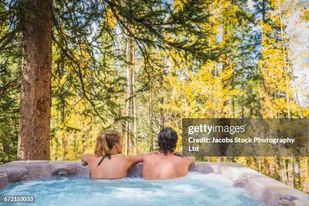 hispanic couple relaxing in hot tub - hot tub stock pictures, royalty-free photos & images