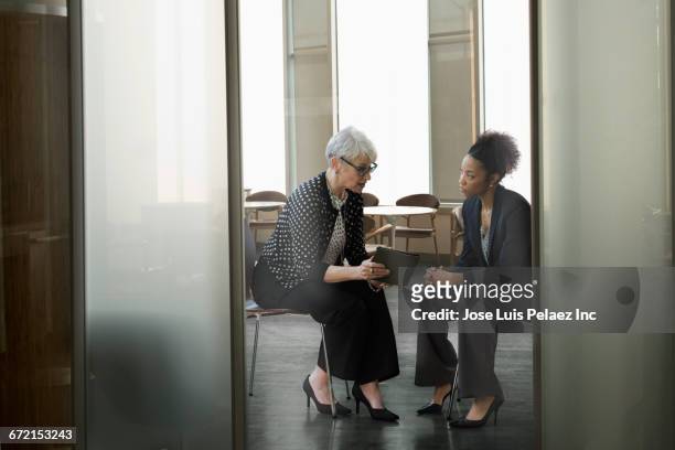 businesswomen using digital tablet in office - formal businesswear stock pictures, royalty-free photos & images