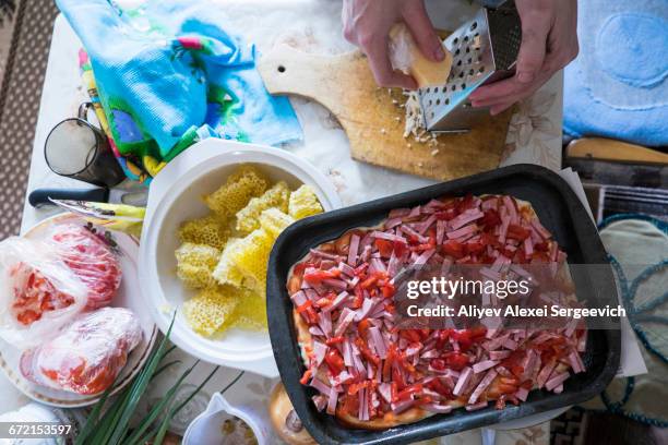 hand grating cheese onto cutting board for pizza - honey ham stock pictures, royalty-free photos & images