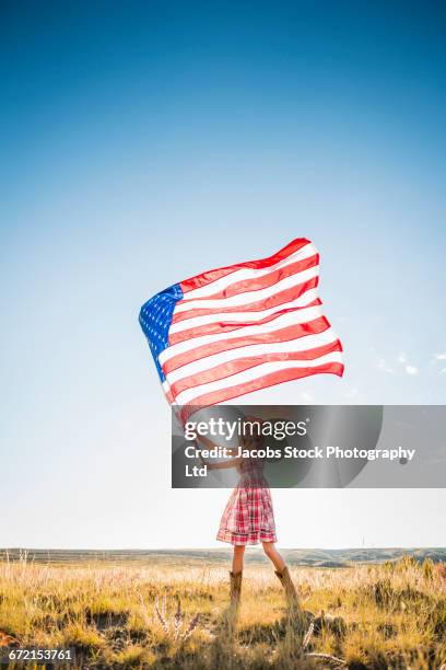 hispanic woman wearing cowboy hat waving american flag in desert - american flag on stand stock pictures, royalty-free photos & images