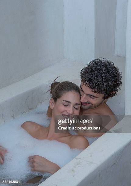 smiling caucasian couple relaxing in bathtub - couple bathtub photos et images de collection