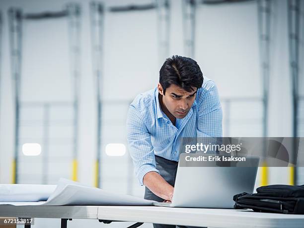 indian architect using laptop in empty warehouse - indian ethnicity laptop stock pictures, royalty-free photos & images