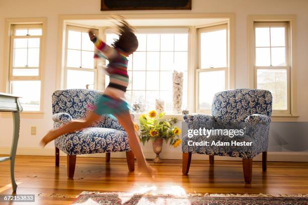 carefree caucasian girl running and jumping in livingroom - spring home interior stock pictures, royalty-free photos & images