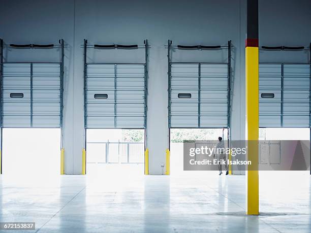 caucasian businessman lifting loading dock door - loading dock 個照片及圖片檔