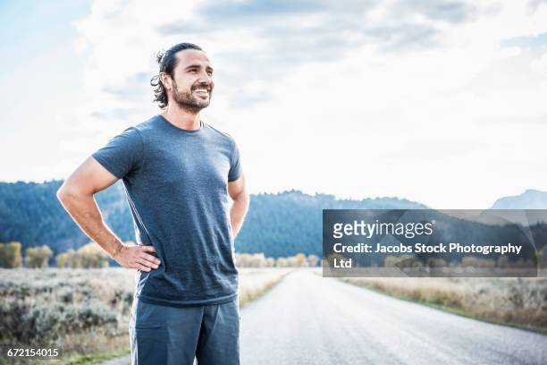hispanic runner resting near mountain - fit man stockfoto's en -beelden