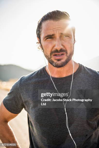 hispanic runner resting and listening to earbuds - walkman closeup stock pictures, royalty-free photos & images