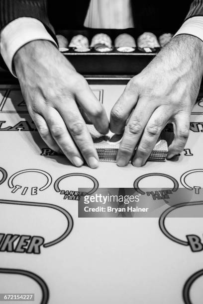 dealer shuffling playing cards at baccarat table - baccarat table fotografías e imágenes de stock