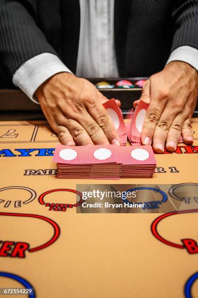 dealer shuffling cards at baccarat table - baccarat table fotografías e imágenes de stock