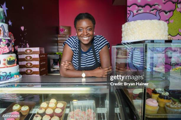 black business owner leaning on bakery display case - cake case stock pictures, royalty-free photos & images