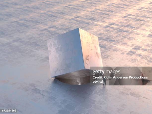 caucasian man examining square metal box in round hole - overcoming problems stock pictures, royalty-free photos & images