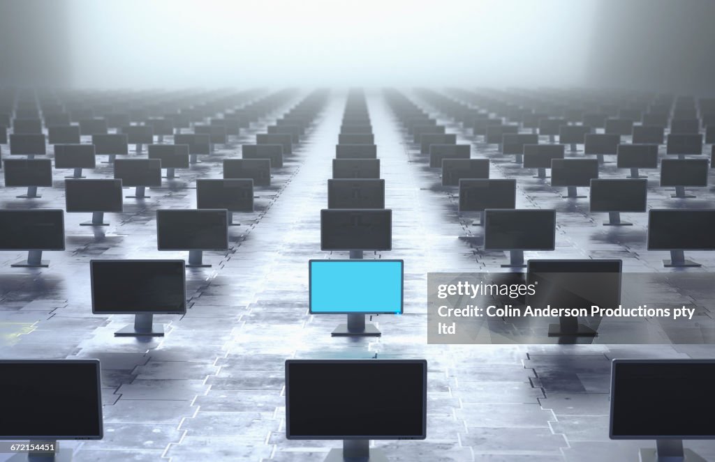 Glowing computer monitor in row of monitors