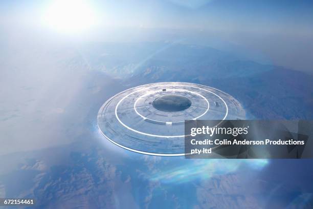 circular ufo flying over mountain landscape - surprise arizona stockfoto's en -beelden