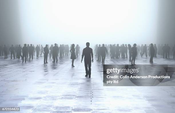 silhouette of man standing out from the crowd - silouhette people stock pictures, royalty-free photos & images