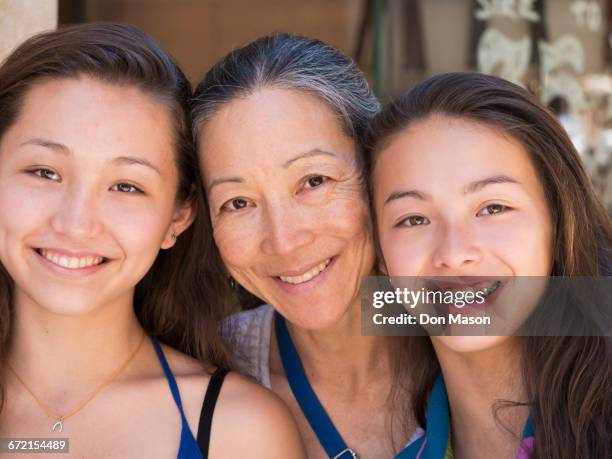 close up of smiling asian mother and daughters - mother with daughters 12 16 stock-fotos und bilder