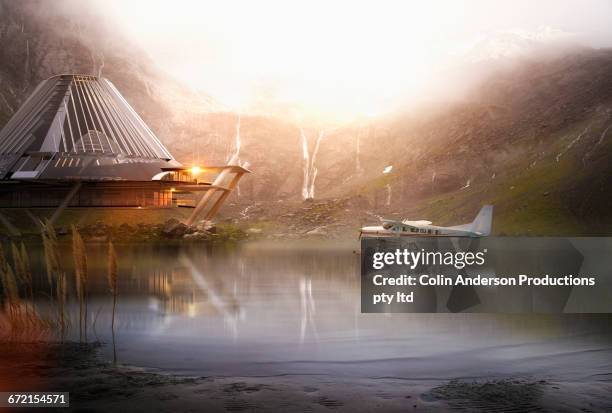 pontoon airplane on lake near futuristic house - private aeroplane stock-fotos und bilder