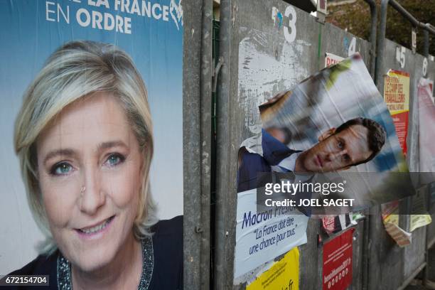 Picture taken on April 24, 2017 in Henin-Beaumont, northern France, shows campaign posters of French presidential election candidate for the...