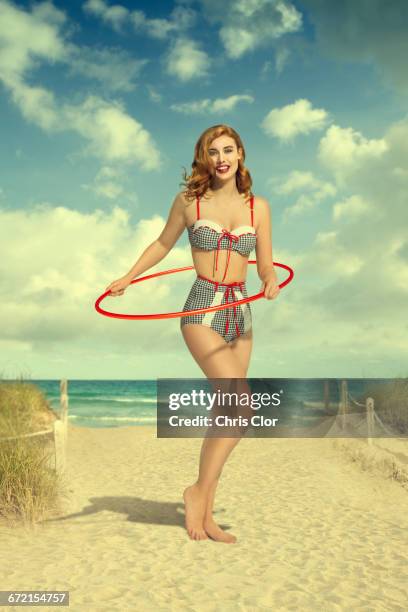 caucasian woman wearing bikini holding plastic hoop at beach - pin up vintage 個照片及圖片檔