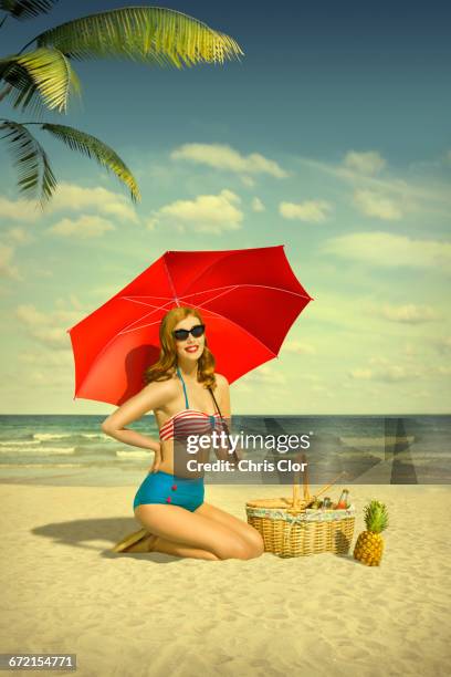 caucasian woman holding red umbrella at beach - miami food stock pictures, royalty-free photos & images