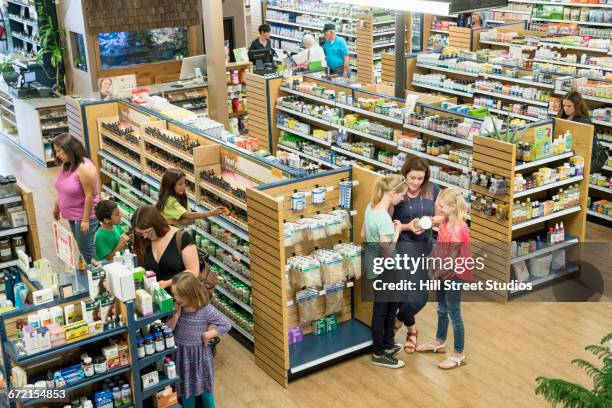 customers browsing in nutrition store - bioladen stock-fotos und bilder