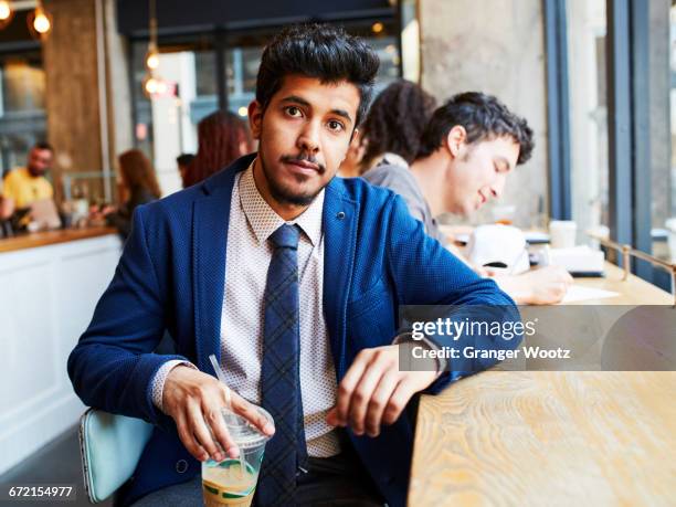 Man drinking cold beverage in cafe