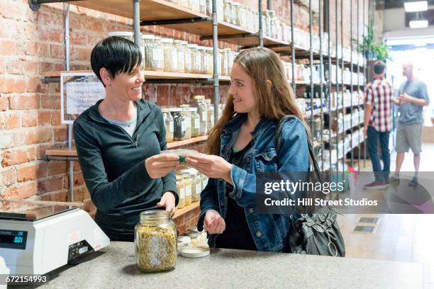 caucasian customer sampling merchandise in nutrition store - bioladen stock-fotos und bilder