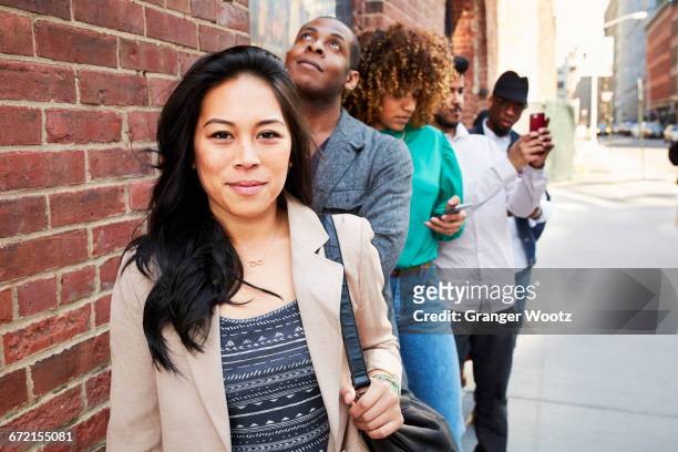 people waiting in line on sidewalk with cell phones - long hair stock pictures, royalty-free photos & images