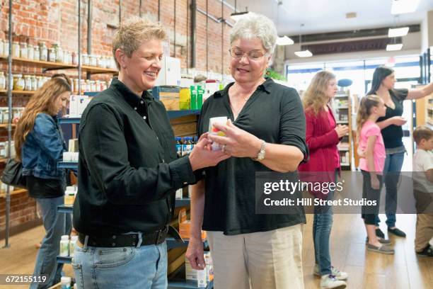 customers browsing in nutrition store - mujeres de mediana edad fotografías e imágenes de stock