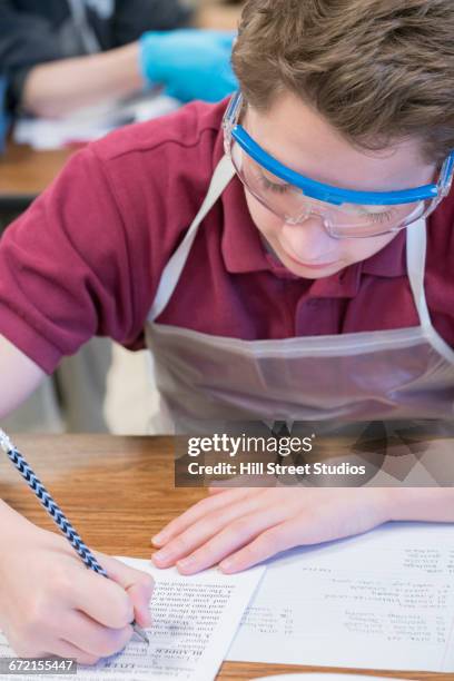 caucasian boy taking test in science classroom - frog dissection stock pictures, royalty-free photos & images