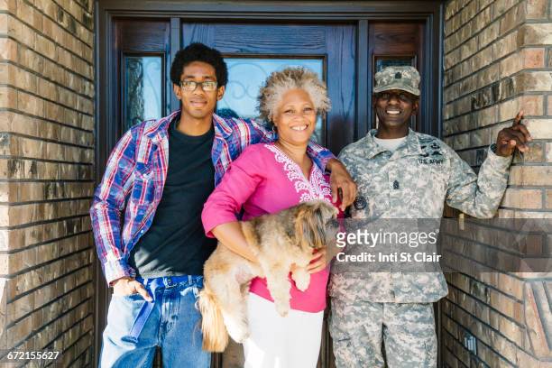 Black family posing with dog in doorway