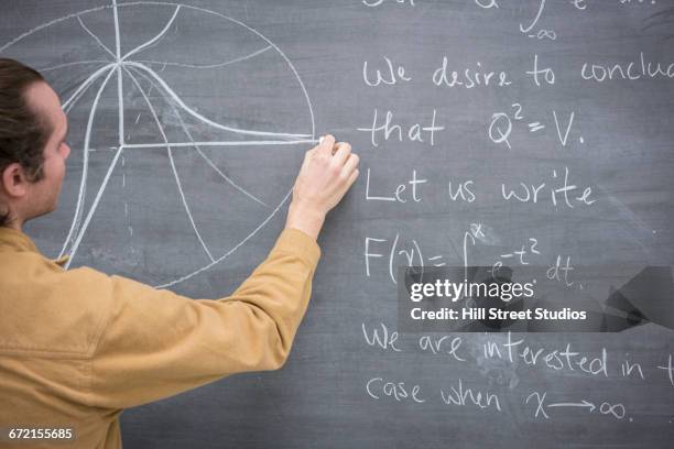 caucasian man drawing diagram on blackboard in classroom - algorithm math chalkboard graphs stock pictures, royalty-free photos & images