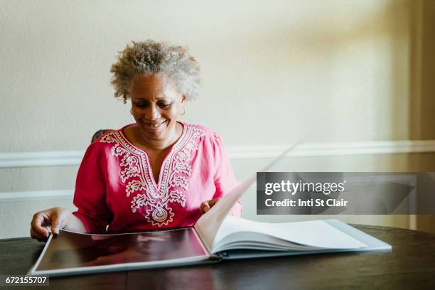 black woman enjoying photo album - turning page stock pictures, royalty-free photos & images