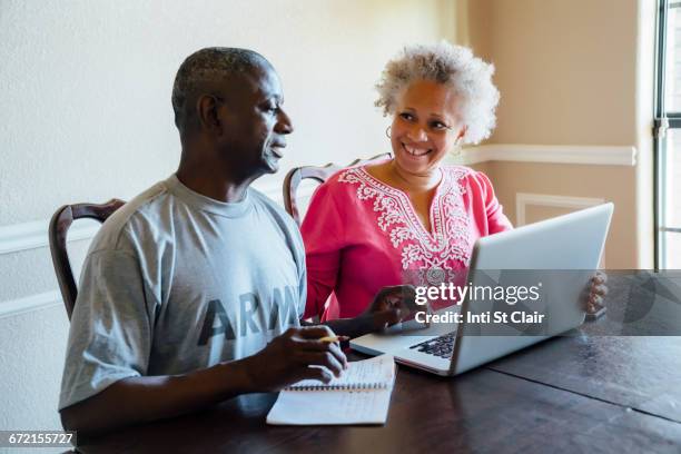black couple using laptop at table - military computer stock pictures, royalty-free photos & images