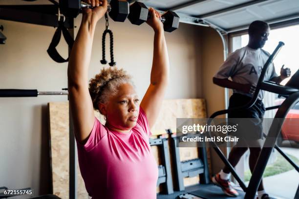 black couple lifting working out in garage - cardiovasculaire training stockfoto's en -beelden