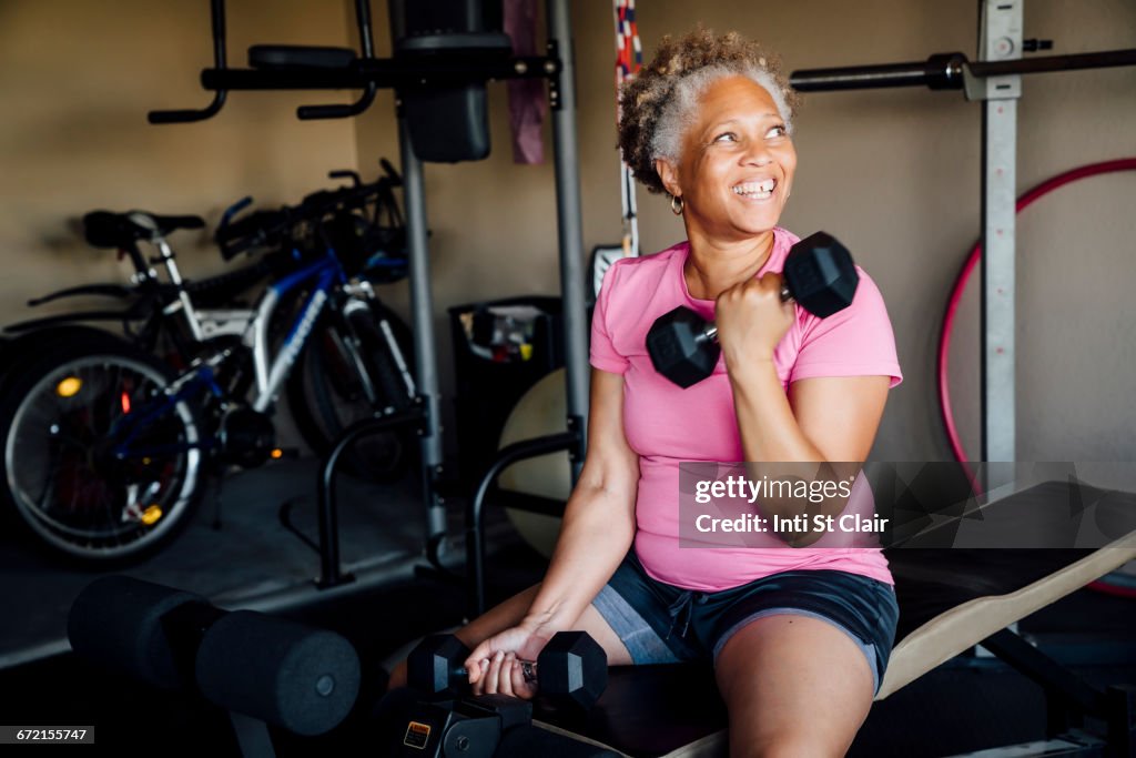 Black woman lifting weights in garage