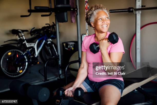 black woman lifting weights in garage - ウエイトトレーニング　女性 ストックフォトと画像